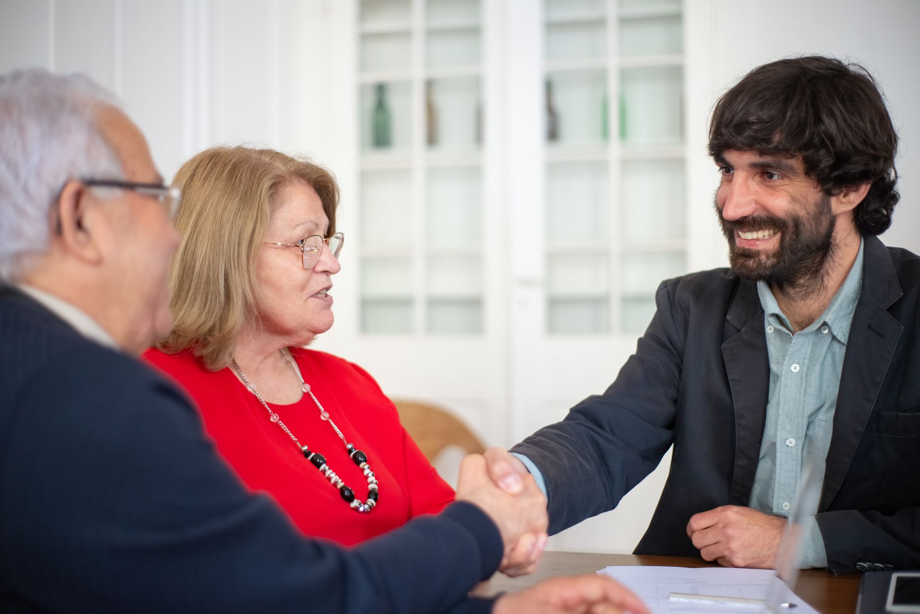 Business advisors sealing an agreement with a handshake in a meeting.